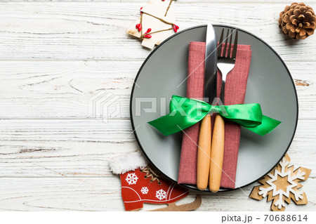 Holiday composition of Christmas dinner on wooden background. Top view of plate, utensil and festive decorations. New Year Advent concept with copy space 70688614