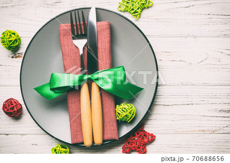 Holiday composition of Christmas dinner on wooden background. Top view of plate, utensil and festive decorations. New Year Advent concept with copy space Holiday composition of Christmas dinner on wooden background. Top view of plate, utensil and festive decorations. New Year Advent concept with copy space 70688656