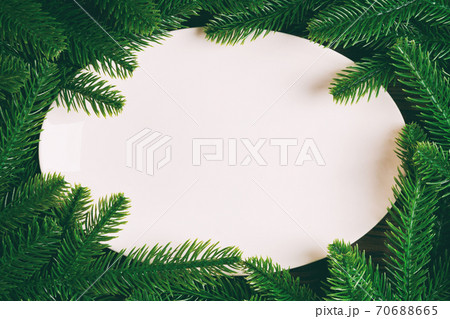 Top view of white plate surrounded with fir tree branches. Christmas dinner concept with copy space 70688665
