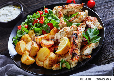 Baked potato halves with grilled chicken strips 70689303