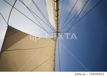 Yellow yacht sails on a blue background. Yellow yacht sails on a blue background. 70690602
