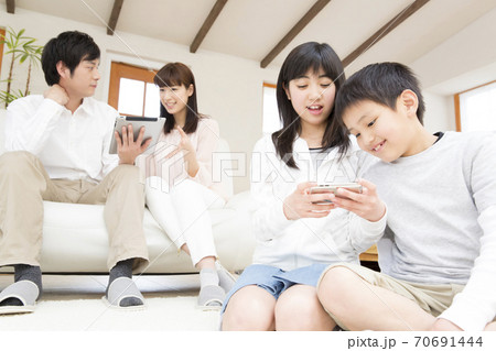 リビングでくつろぐ親子 70691444