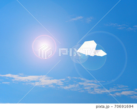 大空を飛ぶ紙ヒコーキの写真素材