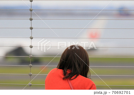 飛行機を眺める女性 後姿 赤い服 飛行機を眺める女性 後姿 赤い服 70692701