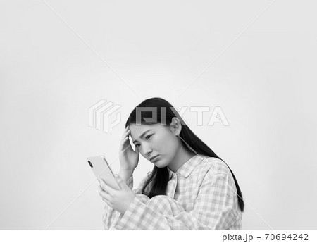 パジャマ姿でスマートフォンを操作する女性イメージ 70694242
