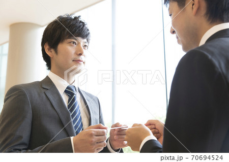 名刺交換をするビジネスマン 70694524