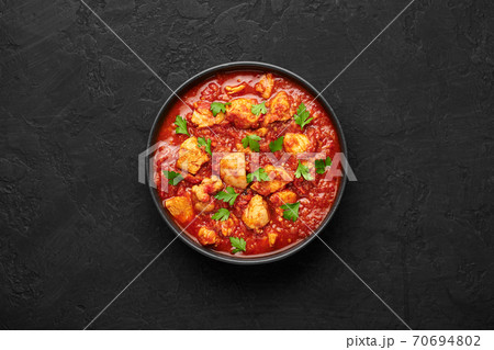 Chicken Madras Curry in black bowl on dark slate table top. Indian cuisine dish with. Asian food  70694802