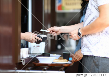 Client pays with bank plastic card in cafe. Client pays with bank plastic card in cafe. 70695113