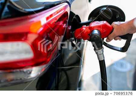 ガソリンスタンドで給油をする男性 ガソリンスタンドで給油をする男性 70695376