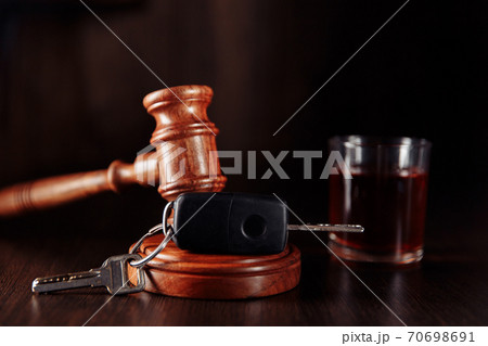 Car key, judge gavel and whiskey alcohol drink in a glass on a wooden table. Don't drink and drive abstract concept 70698691