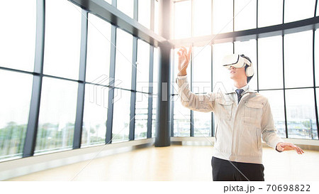 VRゴーグルをつけて動画を見る男性 VRゴーグルをつけて動画を見る男性 70698822