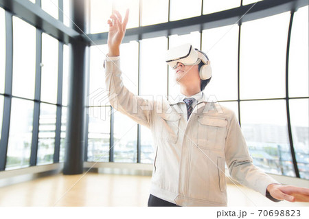 VRゴーグルをつけて動画を見る男性 70698823