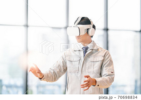 VRゴーグルをつけて動画を見る男性 70698834