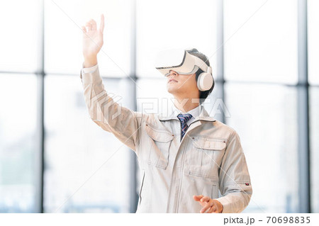 VRゴーグルをつけて動画を見る男性 VRゴーグルをつけて動画を見る男性 70698835