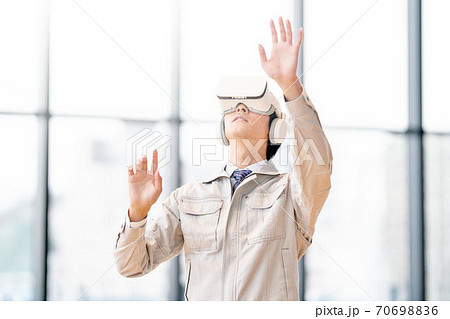 VRゴーグルをつけて動画を見る男性 VRゴーグルをつけて動画を見る男性 70698836