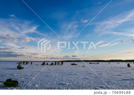 group of fishermen fishing in winter on the ice of the river 70699188
