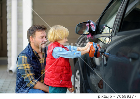Preschooler boy helping his father washing family car. Little dad helper. 70699277
