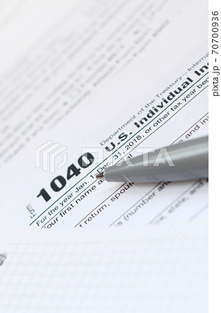 The pen and notebook is lies on the tax form 1040 U.S. Individual Income Tax Return. The time to pay taxes 70700936