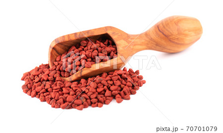 Annatto seeds in wooden scoop, isolated on white background. Achiote seeds, bixa orellana. Natural dye for cooking and food. Close-up. Annatto seeds in wooden scoop, isolated on white background. Achiote seeds, bixa orellana. Natural dye for cooking and food. Close-up. 70701079
