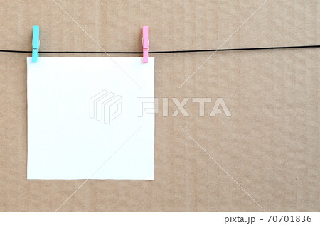 White blank card on rope on a brown cardboard background. Creative reminder, small sheet of paper on wooden clothespin, memo backdrop White blank card on rope on a brown cardboard background. Creative reminder, small sheet of paper on wooden clothespin, memo backdrop 70701836