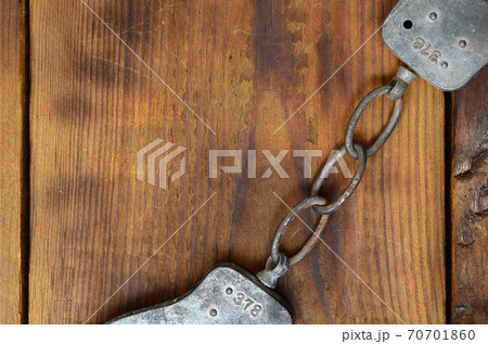 Old and rusty police handcuffs lie on a scratched wooden surface. The concept of an old crime Old and rusty police handcuffs lie on a scratched wooden surface. The concept of an old crime 70701860