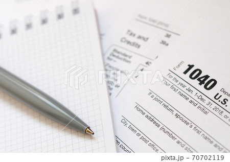 The pen and notebook is lies on the tax form 1040 U.S. Individual Income Tax Return. The time to pay taxes 70702119