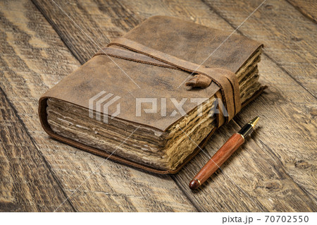 antique leatherbound journal on rustic wood 70702550
