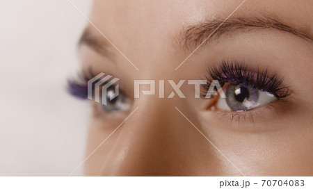 Eyelash Extension Procedure. Close up view of beautiful female eye with long eyelashes, smooth healthy skin. Eyelash Extension Procedure. Close up view of beautiful female eye with long eyelashes, smooth healthy skin. 70704083