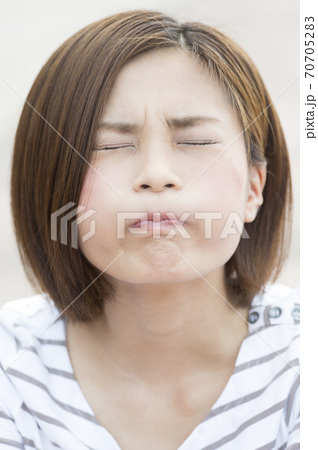 頬を膨らませる女性の写真素材