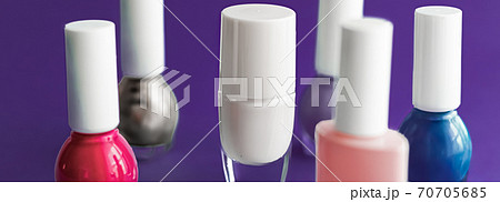 Nail polish bottles on dark purple background, beauty brand 70705685