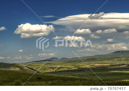 Blue sky from with cold wind blowing from the mountains of the Geghama range moves turbulent cloud with Cumulus clouds covering the villages and valleys in Armenia. Blue sky from with cold wind blowing from the mountains of the Geghama range moves turbulent cloud with Cumulus clouds covering the villages and valleys in Armenia. 70707457