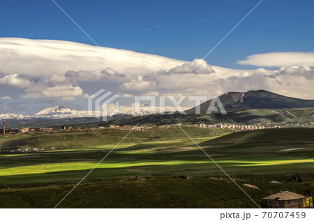 The wind blowing from the Geghama ridge formed a thundercloud in the blue sky with Cumulus clouds moving towards the villages and valleys of Armenia. 70707459