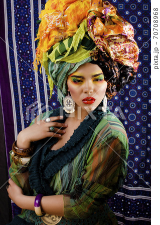beauty bright woman with creative make up, many shawls on head like cubian, ethno look closeup 70708968