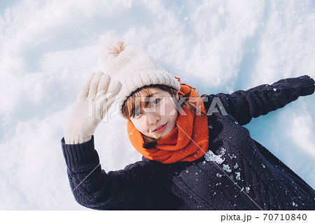 雪の上に寝転がる女の子の写真素材