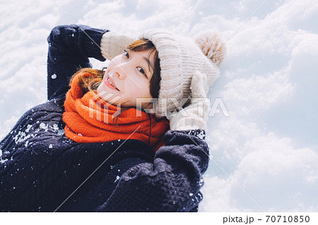 雪の上に寝転がる女の子の写真素材