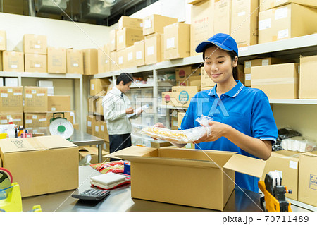 倉庫で梱包作業をする若い女性 70711489