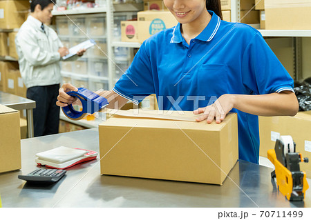 倉庫で梱包作業をする若い女性 70711499
