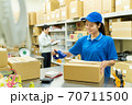 倉庫で梱包作業をする若い女性 70711500