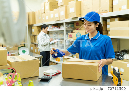 倉庫で梱包作業をする若い女性 70711500