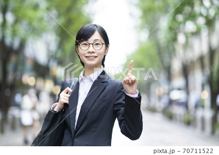 人差し指を立てるポーズをするスーツ姿の若い女性 70711522