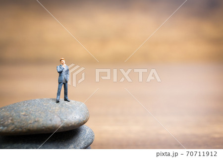 Miniature people : Businessman standing on stone , Challenges and risks Concept 70711912