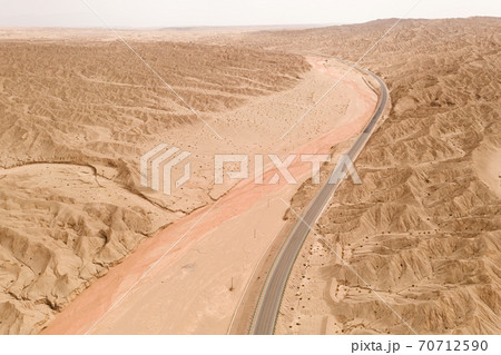 Dryness land with erosion terrain with highway crossing. 70712590