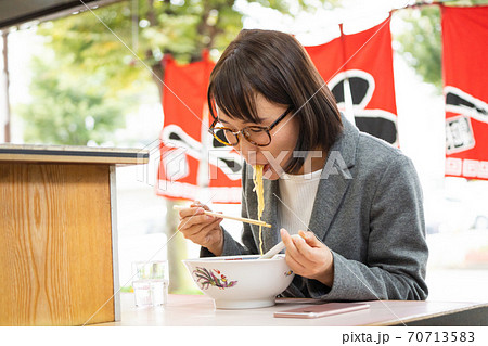 一人でラーメンを食べる若い女性の写真素材