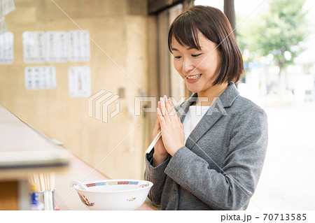 一人でラーメンを食べる若い女性の写真素材