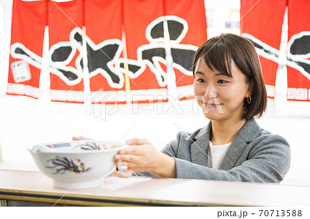 一人でラーメンを食べる若い女性 70713588