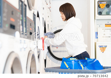 コインランドリーで洗濯する若い女性 70713642