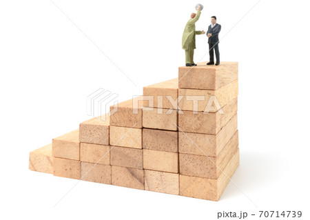 Miniature people: Businessman standing on wood block isolated on white background Miniature people: Businessman standing on wood block isolated on white background 70714739
