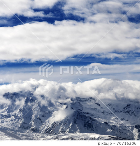 Sunlight snowy mountains in clouds Sunlight snowy mountains in clouds 70716206