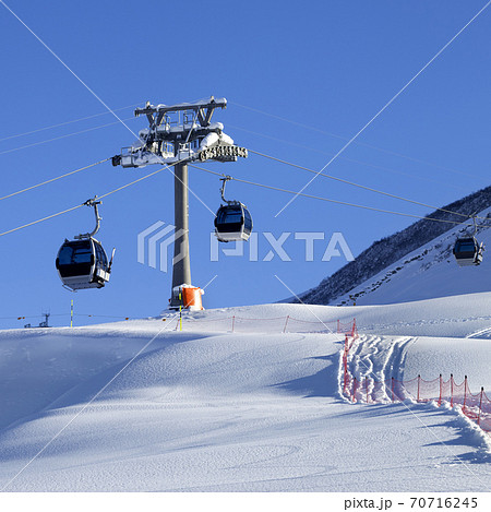 Gondola lift and off-piste slope with new-fallen snow on ski resort at sun evening 70716245