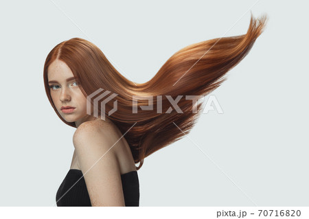 Beautiful model with long smooth, flying red hair isolated on white studio background. Beautiful model with long smooth, flying red hair isolated on white studio background. 70716820